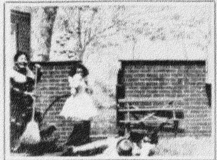 A grainy black and white photo of three children rolling around in the grass next to a penny farthing.